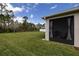 Expansive green backyard, enclosed by a white fence, extending from the screened-in patio with lush views beyond at 3245 Carpentaria Dr, New Smyrna Beach, FL 32168