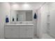 Modern bathroom with a double sink vanity, a large mirror, and a shower at 3245 Carpentaria Dr, New Smyrna Beach, FL 32168