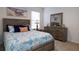 Well-lit bedroom features a charming wood-toned bed frame and dresser with a decorative ocean-themed comforter and artwork at 3245 Carpentaria Dr, New Smyrna Beach, FL 32168