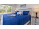 Comfortable bedroom with a large window, carpet flooring, and a beach painting on the wall at 3245 Carpentaria Dr, New Smyrna Beach, FL 32168