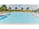 Community pool with chairs, palm trees, and well maintained clear, blue water at 3245 Carpentaria Dr, New Smyrna Beach, FL 32168