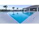 Large clear blue community pool and a recreation building with tables and chairs at 3245 Carpentaria Dr, New Smyrna Beach, FL 32168