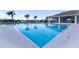 Large clear blue community pool and a recreation building with tables and chairs at 3245 Carpentaria Dr, New Smyrna Beach, FL 32168