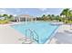 Large clear blue community pool and a recreation building, tables, chairs and lounge chairs at 3245 Carpentaria Dr, New Smyrna Beach, FL 32168