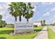 Coastal Woods community sign featuring lush landscaping and swaying palm trees at 3245 Carpentaria Dr, New Smyrna Beach, FL 32168