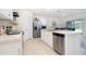 Well-lit kitchen featuring stainless steel appliances, white cabinetry, and a functional layout at 3245 Carpentaria Dr, New Smyrna Beach, FL 32168