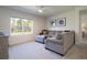 Bright living room with plush carpet, a comfortable sofa, and a large window showcasing the outdoors at 3245 Carpentaria Dr, New Smyrna Beach, FL 32168