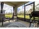 Enclosed back patio has neutral tones, an outdoor rug, and is framed by large windows with views of the lush backyard at 3245 Carpentaria Dr, New Smyrna Beach, FL 32168