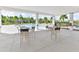 A poolside patio area with tables and chairs for relaxing by the community pool, surrounded by palm trees at 3245 Carpentaria Dr, New Smyrna Beach, FL 32168