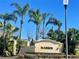 Welcoming entrance to the Marisol community, featuring lush landscaping and palm trees under a bright blue sky at 3611 Marisol Ct, New Smyrna Beach, FL 32168