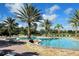 Large community pool with chairs and tropical trees at 3611 Marisol Ct, New Smyrna Beach, FL 32168