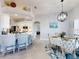 Open-concept kitchen and dining area featuring stainless steel appliances, bar seating, and a charming dining set at 3611 Marisol Ct, New Smyrna Beach, FL 32168