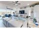 Bright living room with large windows, TV, and comfortable seating overlooking an outdoor patio with water views at 3611 Marisol Ct, New Smyrna Beach, FL 32168