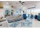 Living room featuring a ceiling fan, comfortable seating, coastal decor, and adjacent dining area with water views at 3611 Marisol Ct, New Smyrna Beach, FL 32168
