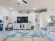 Bright living room featuring a TV, ceiling fan, coastal decor, and comfortable seating with a tropical area rug at 3611 Marisol Ct, New Smyrna Beach, FL 32168