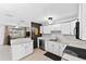 Bright kitchen features white cabinetry and countertops, with a view to the living area and front yard at 38 Seacrest Dr, Ormond Beach, FL 32176