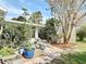 Landscaped backyard featuring potted plants, bird feeders, a bench, and other outdoor decor at 403 Wildwood Dr, Edgewater, FL 32132