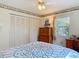 Bright bedroom features a window, ceiling fan, and closet with bi-fold doors at 403 Wildwood Dr, Edgewater, FL 32132