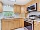 This kitchen features wood cabinets, stainless steel appliances, and tiled floors at 403 Wildwood Dr, Edgewater, FL 32132