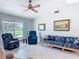 Comfortable living room with vaulted ceiling, large windows, and cozy seating area with wicker furniture at 403 Wildwood Dr, Edgewater, FL 32132