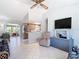 Bright living room featuring tile floors, ceiling fan, and an opening to the kitchen with stainless steel appliances at 403 Wildwood Dr, Edgewater, FL 32132
