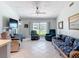 Inviting living room with tile flooring, wicker furniture, and a view to the outdoors through a large window at 403 Wildwood Dr, Edgewater, FL 32132