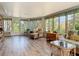Light-filled sunroom featuring wood floors and views of lush greenery at 403 Wildwood Dr, Edgewater, FL 32132