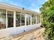 Bright sunroom with expansive windows offering views of the surrounding lush landscaping at 403 Wildwood Dr, Edgewater, FL 32132