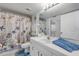 Well-lit bathroom featuring a stylish shower curtain and a clean white vanity at 407 Bouchelle Dr # 205, New Smyrna Beach, FL 32169