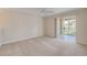 Bright bedroom featuring neutral tones and a sliding glass door to a private balcony with lush landscaping at 407 Bouchelle Dr # 205, New Smyrna Beach, FL 32169