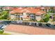 Beautiful condominium complex featuring lush landscaping, a terracotta roof, and ample parking at 407 Bouchelle Dr # 205, New Smyrna Beach, FL 32169