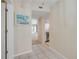 Hallway view of kitchen, entryway and the living room with white tiled floors and neutral wall paint at 407 Bouchelle Dr # 205, New Smyrna Beach, FL 32169