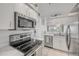 Updated kitchen featuring stainless steel appliances, white cabinetry, and ample counter space at 407 Bouchelle Dr # 205, New Smyrna Beach, FL 32169