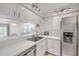 Bright kitchen with stainless steel appliances, white cabinetry, and a view into the dining area at 407 Bouchelle Dr # 205, New Smyrna Beach, FL 32169