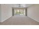 Bright, carpeted living room with sliding glass doors leading to a balcony, ceiling fan and neutral paint at 407 Bouchelle Dr # 205, New Smyrna Beach, FL 32169