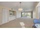 Bright living room features plush carpet, stylish light fixture, and balcony access at 407 Bouchelle Dr # 205, New Smyrna Beach, FL 32169