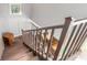 A look down the stairway with wood flooring and metal railing leading to a partially visible seating area at 4150 S Atlantic Ave # 119C, New Smyrna Beach, FL 32169