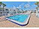 Beautiful community pool with brick deck, surrounded by lounge chairs and lush landscaping at 4225 S Atlantic Ave # 2070, New Smyrna Beach, FL 32169