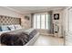 Bedroom featuring a tufted headboard, shuttered window, and light wood floors at 4225 S Atlantic Ave # 2150, New Smyrna Beach, FL 32169