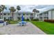 Community view with patio area, seating, and lush landscaping and palm trees at 4225 S Atlantic Ave # 2150, New Smyrna Beach, FL 32169