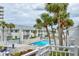Resort pool area surrounded by palm trees, white fencing and community buildings at 4225 S Atlantic Ave # 2150, New Smyrna Beach, FL 32169