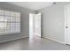 Neutral bedroom featuring a window with blinds, light grey tile flooring, and white trim at 4583 Barnacle Dr, Port Orange, FL 32127