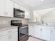 Well-lit kitchen featuring white cabinets, stainless steel appliances, and granite countertops at 4583 Barnacle Dr, Port Orange, FL 32127