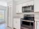 This kitchen features white cabinets, modern stainless steel appliances, and tile flooring at 4583 Barnacle Dr, Port Orange, FL 32127