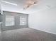 Bright living room featuring neutral tones, two windows with blinds, and carpet flooring at 4583 Barnacle Dr, Port Orange, FL 32127