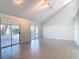 Spacious living room with vaulted ceilings, sliding glass doors, and neutral tile flooring at 4583 Barnacle Dr, Port Orange, FL 32127