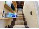 Carpeted staircase leading to an attic with items stored on shelves at 519 Mobile Ave, Daytona Beach, FL 32118