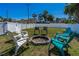 The large backyard features a circular fire pit surrounded by an assortment of chairs at 519 Mobile Ave, Daytona Beach, FL 32118