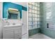 Stylish bathroom with a glass block shower wall, decorative mirror, and modern fixtures at 519 Mobile Ave, Daytona Beach, FL 32118