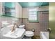 Vintage bathroom featuring sink, toilet, and tiled walls at 519 Mobile Ave, Daytona Beach, FL 32118